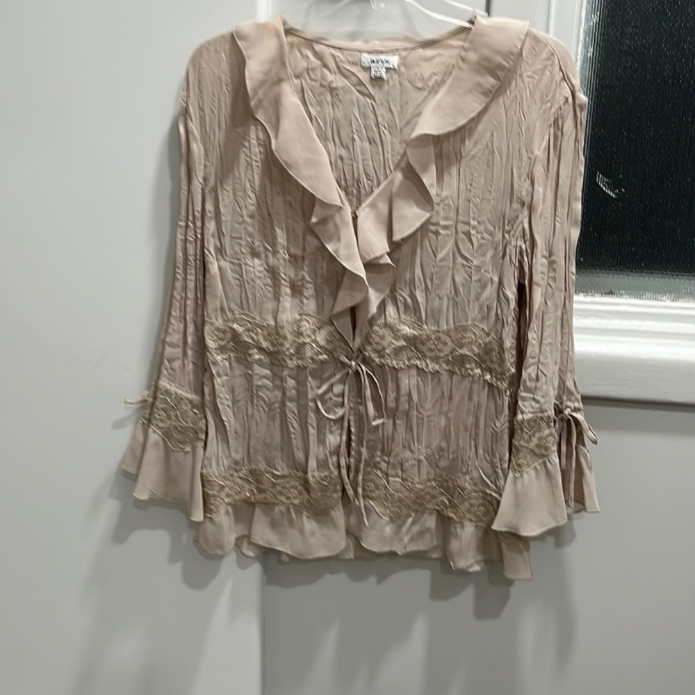 Beige lacy, and feminine long -sleeved button down blouse.